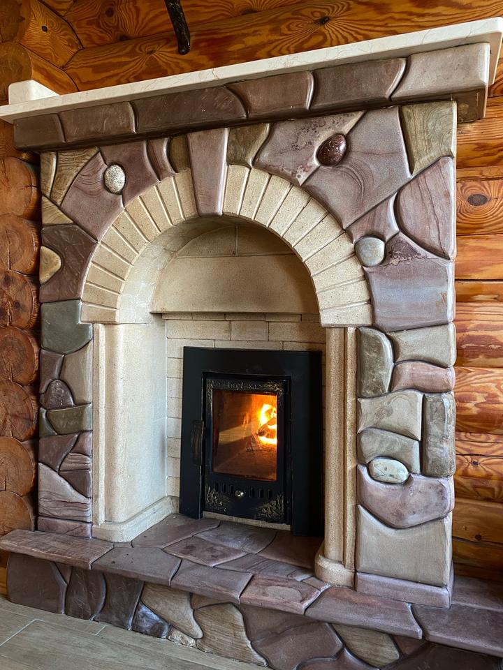 Enclosed firebox framed by a detailed stone fireplace surround